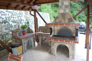 a patio with a stone fireplace on a patio at Guest House Savina in Plachkovtsi