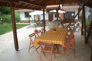 a wooden table and chairs on a patio at Guest House Savina in Plachkovtsi