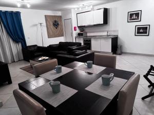 a living room with a dining table and a kitchen at Melia Dunas Ilha do Sal Apartamentos in Santa Maria