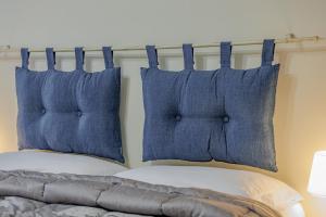 ローマにあるPigneto Smart Apartmentの- ベッドの上に座る青い枕2つ