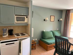 a small kitchen with a couch and a microwave at Studio cabine 5 personnes in Monflanquin +12 photos