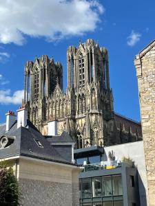 un edificio con una gran catedral en el fondo en Duplex hammam au pied de la Cathédrale avec vue en Reims