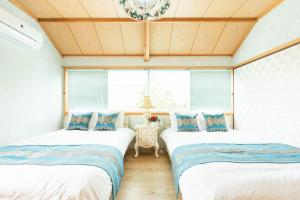 two twin beds in a room with windows at 雨でも炭でBBQが出来る/プール付き!MAX12名/駐車2台可能! in Shirahama +48 photos