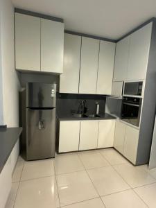 a kitchen with white cabinets and a stainless steel refrigerator at CASA MEBA in Aguascalientes