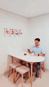 a man sitting at a table with a plate of food at 京都Kyoto Home 2BR - 53 Sqm at Downtown Semarang in Semarang