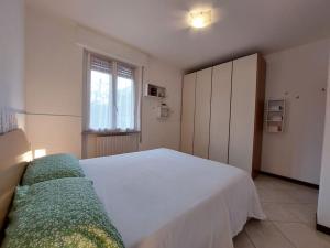ein Schlafzimmer mit einem großen weißen Bett und einem Fenster in der Unterkunft Mandello Panoramico in Mandello del Lario