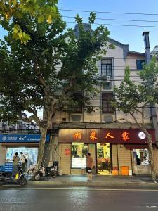 una tienda al lado de una calle con un árbol en Shanghai Downtown Yidu B&B - Near South Shaanxi Road Metro Station, en Shanghái