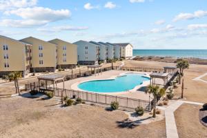uma vista aérea de um resort com uma piscina e o oceano em OceanScape- Beach, Pool, and Sun near the heart of Surf City! em Surf City