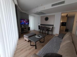 a living room with a couch and a table at 19th Floor Secure Condo with Pool, Fitness, Parking Included in Price in Skopje