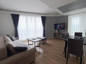 a living room with a couch and a table at 19th Floor Secure Condo with Pool, Fitness, Parking Included in Price in Skopje