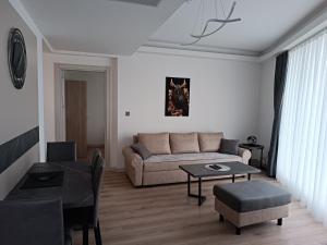 a living room with a couch and a table at 19th Floor Secure Condo with Pool, Fitness, Parking Included in Price in Skopje