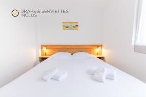 a white bed with two white pillows on it at ROSCAROC ENEZ AR BEG - Charmant T2 proche plage in Ploudalmézeau +55 photos