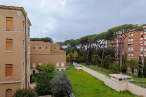 ローマにあるPigneto Smart Apartmentの木の植わる庭と建物の景色を望む