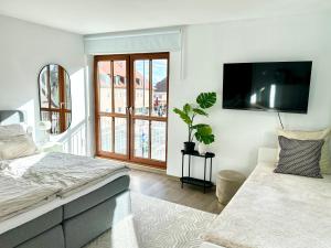 a bedroom with a bed and a flat screen tv at Wohnung Alte Mainbrücke - GRATIS KAFFEE - NETFLIX - BALKON in Würzburg