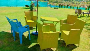 a group of chairs and a table in a field at Hotel River View Resort in Pahalgām