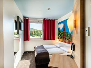 Un pat sau paturi într-o cameră la B&B Hotel Freiburg-Süd