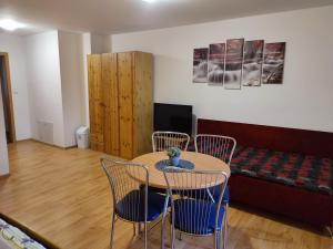 a living room with a table and chairs and a couch at Apartmany Zachar in Bešeňová