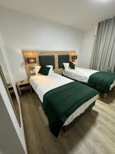 ブリュマトにあるHôtel NOROTELのホテルルーム ベッド2台&緑のシーツ付