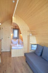 ein Zimmer mit Sofa und Bett in einem Haus in der Unterkunft Schwimmpod an der Peene in Anklam