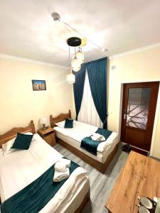 a hotel room with two beds and a chandelier at Hotel Rizvan Buhara in Bukhara +34 photos