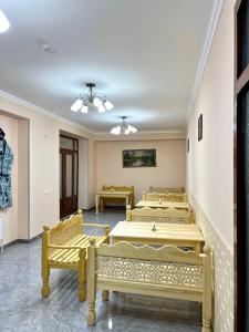 a row of beds in a room with a staircase at Antique Hotel Rizvan in Bukhara