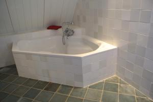 a bath tub with a faucet in a bathroom at Topzomer in Sleat in Sloten +10 photos