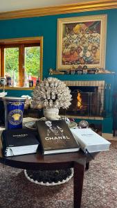a room with a table with books and a fireplace at Pousada de Charme Vila Natal - Exclusive Boutique in Campos do Jordão