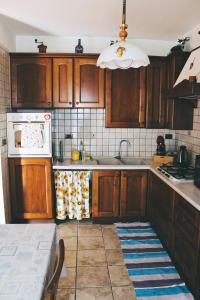 La cuisine est équipée de placards en bois et d'une cuisinière blanche. dans l'établissement Casa Mira - Ampio, fully equipped e zona tranquilla, à Trieste