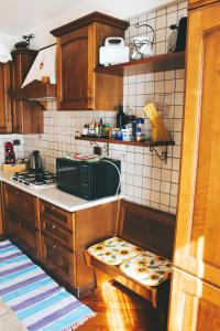 La cuisine est équipée de placards en bois, d'un évier et d'un four micro-ondes. dans l'établissement Casa Mira - Ampio, fully equipped e zona tranquilla, à Trieste