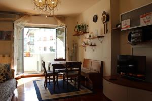 d'une salle à manger avec une table, des chaises et une fenêtre. dans l'établissement Casa Mira - Ampio, fully equipped e zona tranquilla, à Trieste