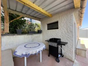 a grill and a table on a patio at Maison du Pont de la Roussie in CazoulÃ¨s