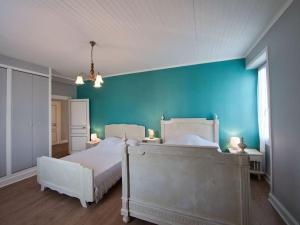 a bedroom with two beds and a blue wall at Maison du Pont de la Roussie in CazoulÃ¨s +19 photos