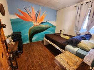 1 dormitorio con una pintura de pavo real en la pared en Boho by Arte Hostal Boquete, en Bajo Boquete
