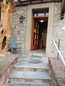 ein Steinhaus mit einer Treppe, die zu einer Tür führt in der Unterkunft Gästehaus Burg Molbach in Kreuzau