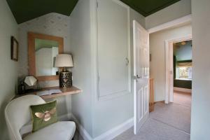 a living room with a chair and a mirror at Cosy Cottage, Central Ludlow, Free Parking, Boutique Hotel Style in Ludlow