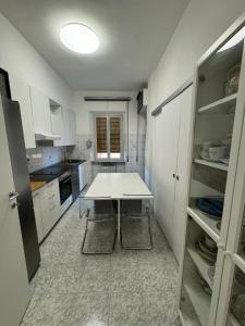 une petite cuisine avec une table blanche et des armoires dans l'établissement VinicioRossiApartment, à Ancône