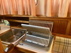 a kitchen with a sink and a dish drying rack at Disfruta del mar cerca de Barcelona in Castelldefels