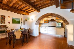 - une cuisine avec une arche, une table et des chaises dans l'établissement Podere Torre degli Ulivi, à Palaia