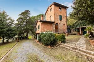 un antiguo edificio de ladrillo con una torre en un patio en Podere Torre degli Ulivi, en Palaia