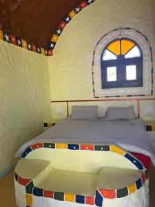 ein Schlafzimmer mit einem Bett in einem Zimmer mit einem Fenster in der Unterkunft Anakato lodge in Al Manshīyah