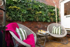 two wicker chairs and a table on a patio at Cosy Cottage, Central Ludlow, Free Parking, Boutique Hotel Style in Ludlow
