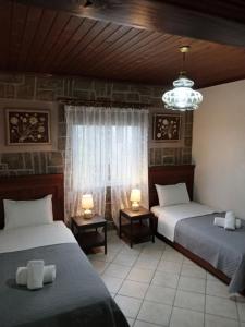 a bedroom with two beds and a chandelier at Elaias Gea -Kalampaka in Kalabaka