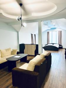 sala de estar con sofá, mesa y cama en Meatsa Hotel en Kŭrdzhali