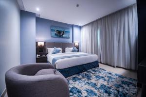 Habitación de hotel con cama y silla en فنـــــــــدق ايليفــــــــــــار Elevar Hotel en Al Khobar