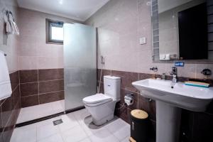 a bathroom with a toilet and a sink and a shower at فنـــــــــدق ايليفــــــــــــار Elevar Hotel in Al Khobar
