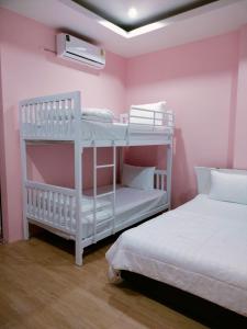 two bunk beds in a room with pink walls at Hana Villa Hatyai in Suen Phra