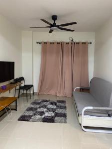 Igo homestay - Family Room في شاه عالم: غرفة معيشة مع أريكة ومروحة سقف