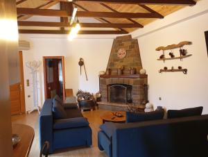 ein Wohnzimmer mit blauen Sofas und einem Kamin in der Unterkunft La Nature in Konístrai