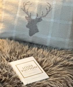 a book sitting on top of a bed with a moose pillow at Ski Suites - A Luxury Maisonette Kalavryta in Kalavrita