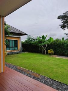 a backyard with a lawn and a house at Hana Villa Hatyai in Suen Phra